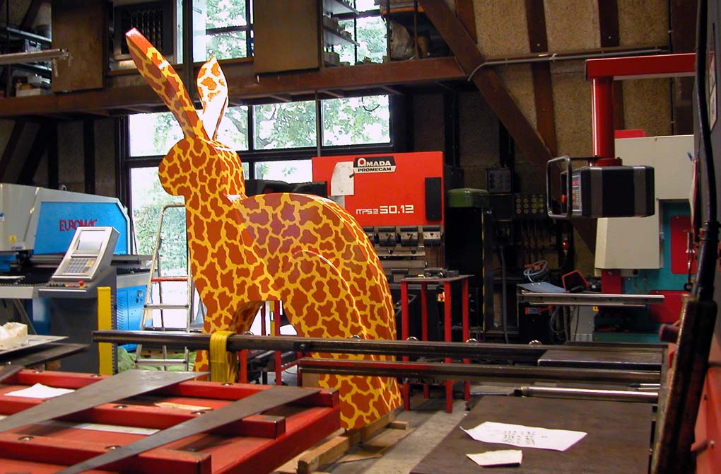 Tussen apparaten staat het geschilderde beeld Dit is een giraf, ceci est une girafe, this is a giraf, © André Boone