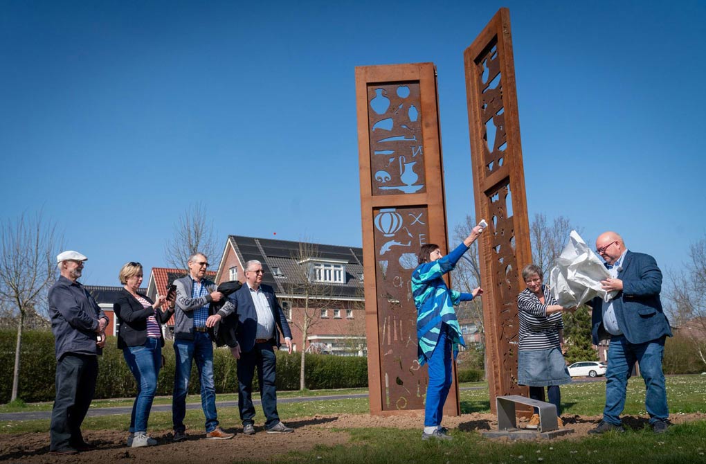 Wethouder Theo Jansen (rechts) onthult samen met Irene Loeff (streepjesshirt) en Mieke Bles (blauw) het kunstwerk Forës op Loovelden. © Erik van 't Hullenaar