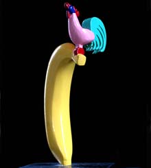 In kleur een rechtopstaande banaan met daarop een haan © André Boone