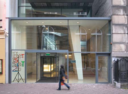 het neonwerk Het is niet zo voor de ingang van het logement. Het gebouw waar de parlementaire enquête commissie zitting heeft © André Boone