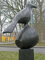 bronzen beeld, titel Nomen Nescio is een opeenstapeling van drie elementen: de zuil of sokkel, een omgevallen kopje en soort kraai-achtige vogel, © André Boone