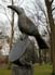 bronzen beeld, titel Nomen Nescio is een opeenstapeling van drie elementen: de zuil of sokkel, een omgevallen kopje en soort kraai-achtige vogel