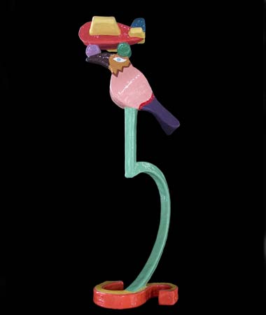 Voor de spelende mens. Op de letter s staat een hefboomsleutel. Hierop zit een vogel met op zijn kop een vliegtuig. Het is gemaakt in polyester en is beschilderd in verschillende kleuren. © André Boone