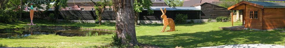 in de grote tuin van de galerie bij de vijver een gekleurde verticale vis, een haas met de schutskleuren van een giraf en in het huisje een installatie voor theo, ©andré boone